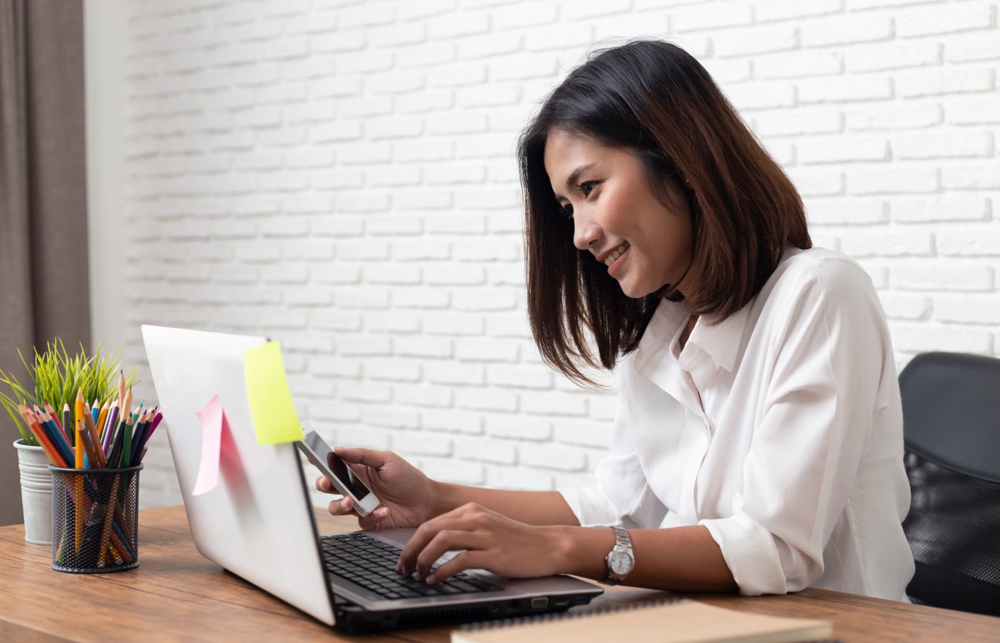 woman at laptop on phone