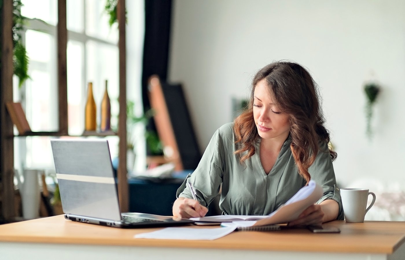 person working with paper and laptop