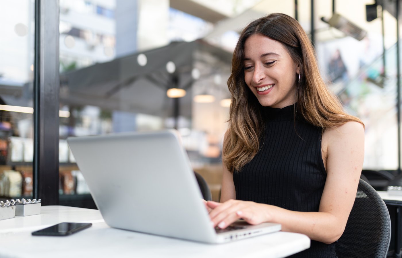 woman outside on laptop smiling