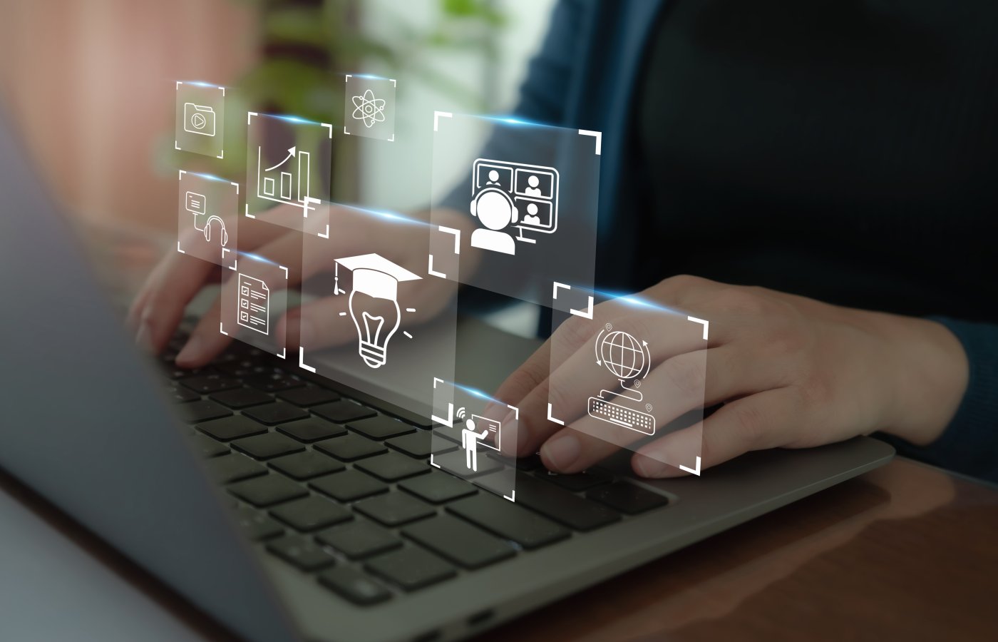 hands on keyboard with learning icons floating above