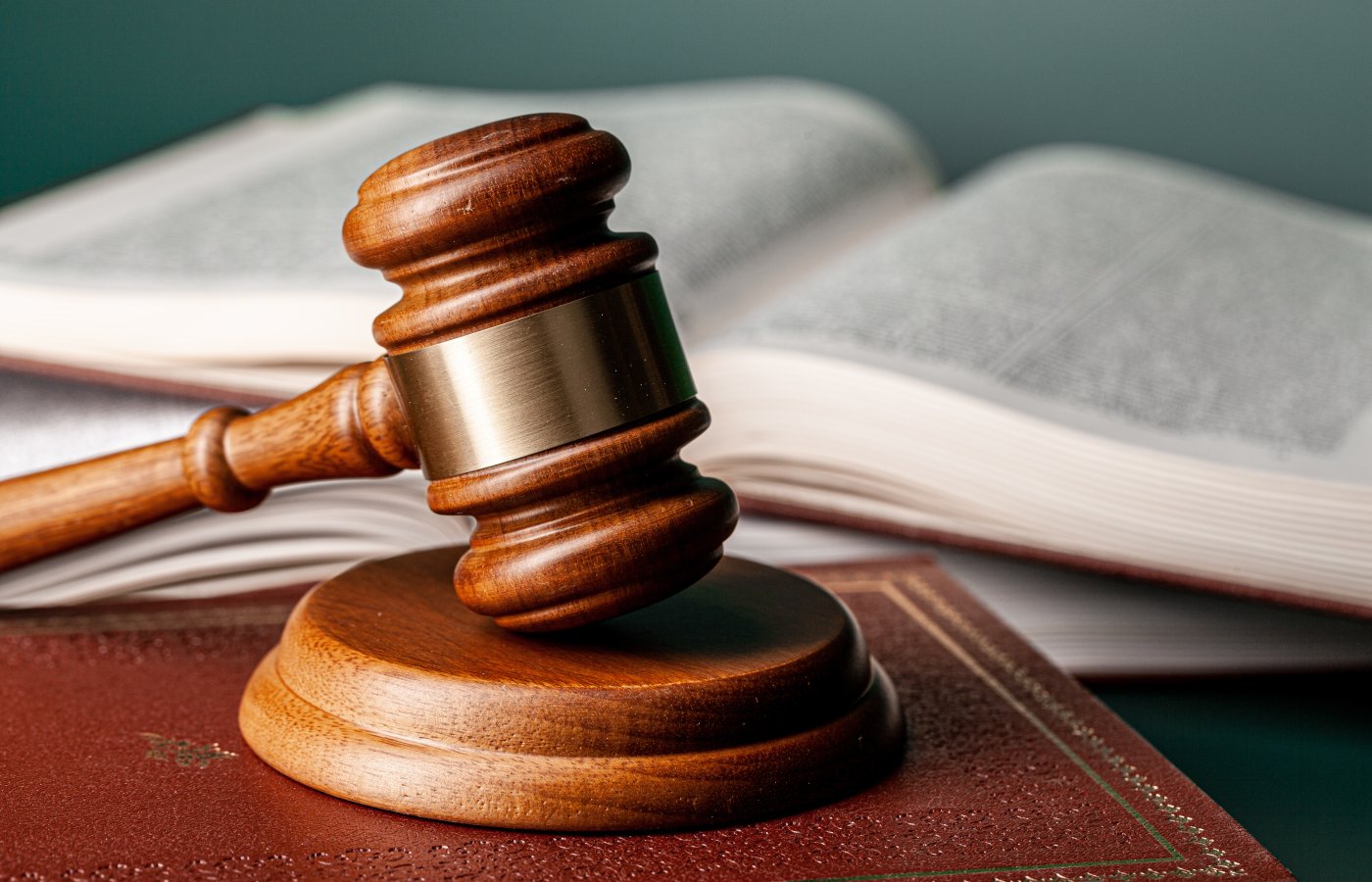Gavel resting on a table with law books in the background