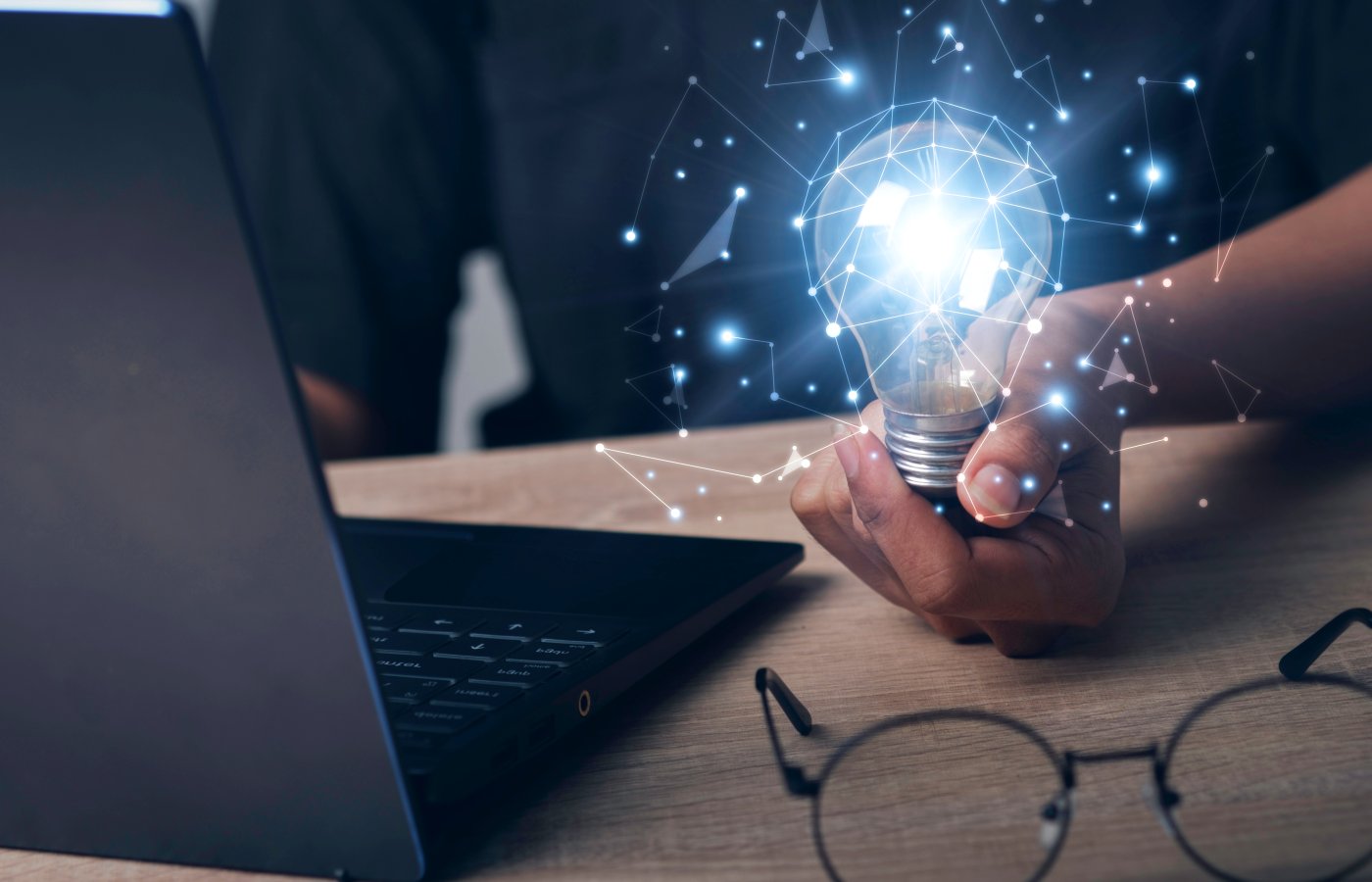 close up of a hand holding a lightbulb lit up to convey spark of ideas and thoughts