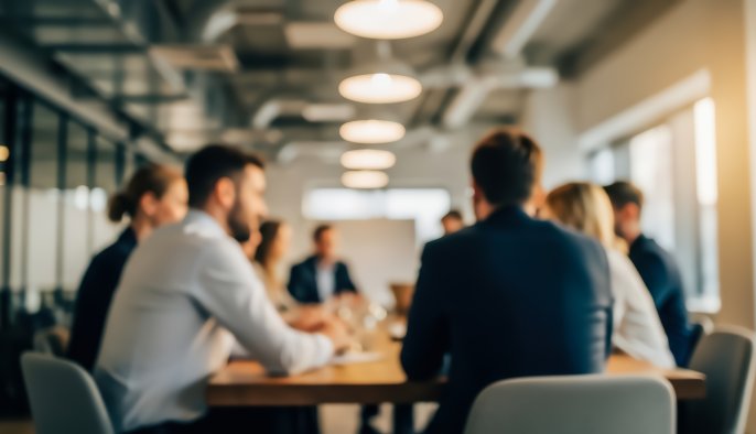 blurred image of a group of people meeting in an office environment
