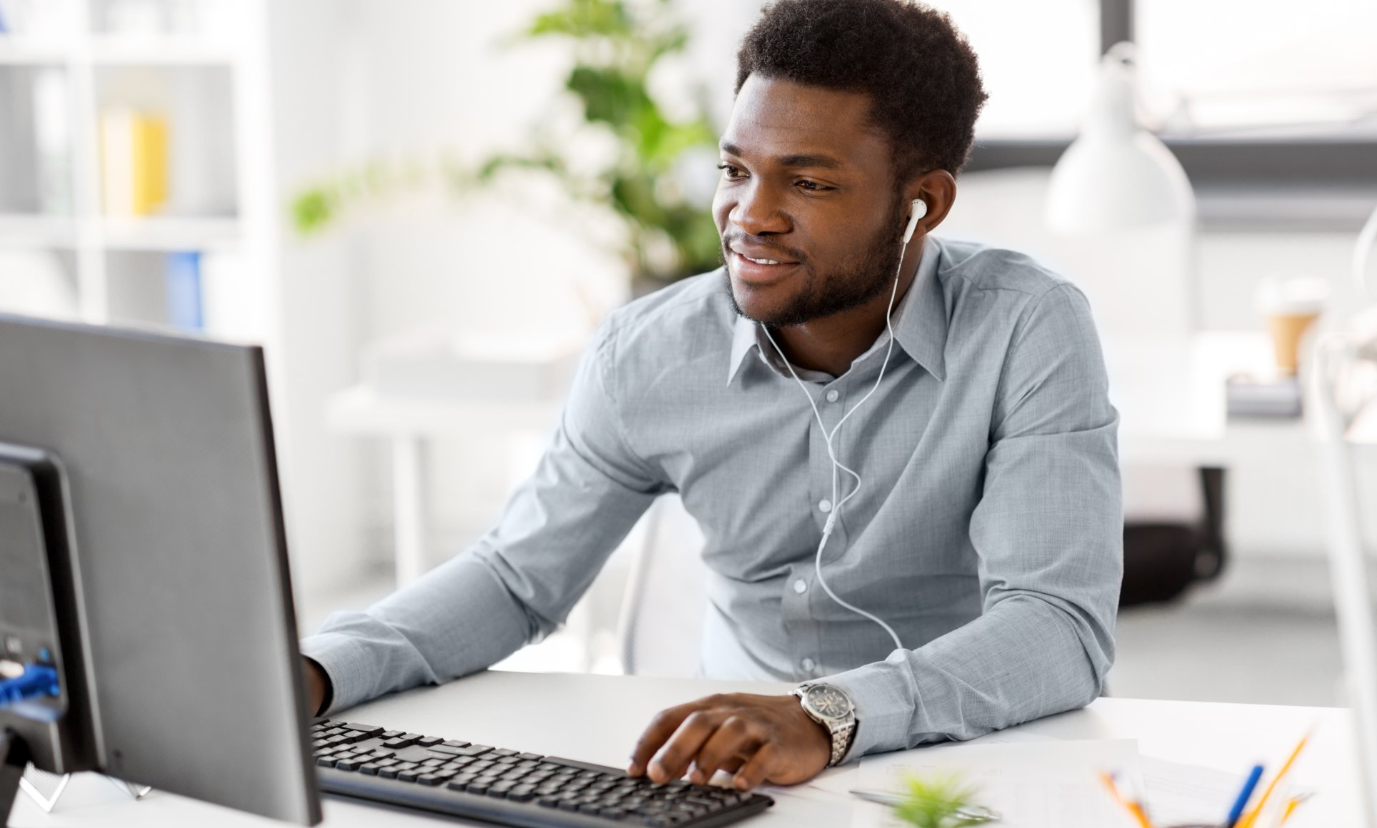 man looking at computer screen with headphones in