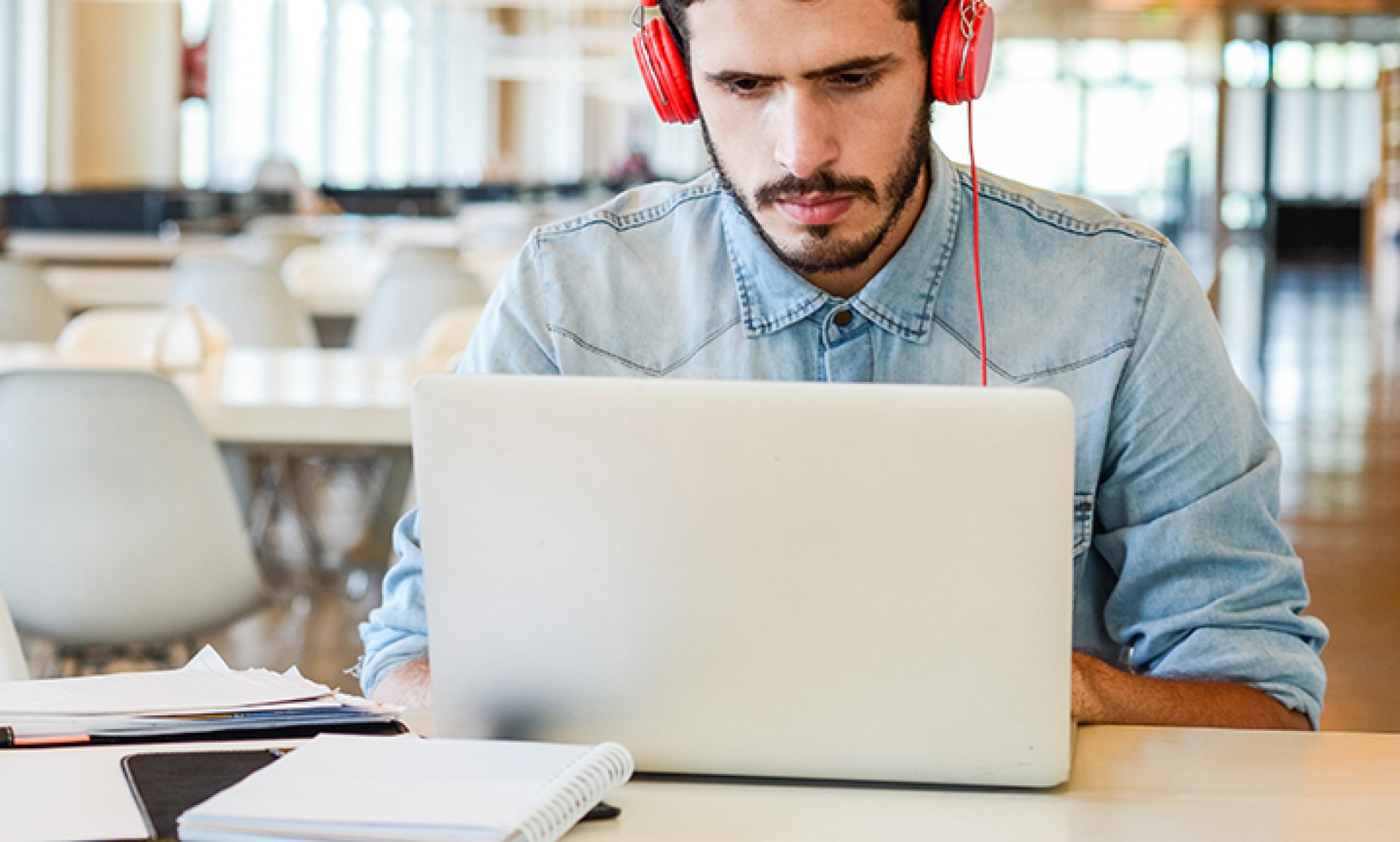 man looking at laptop with headphones on