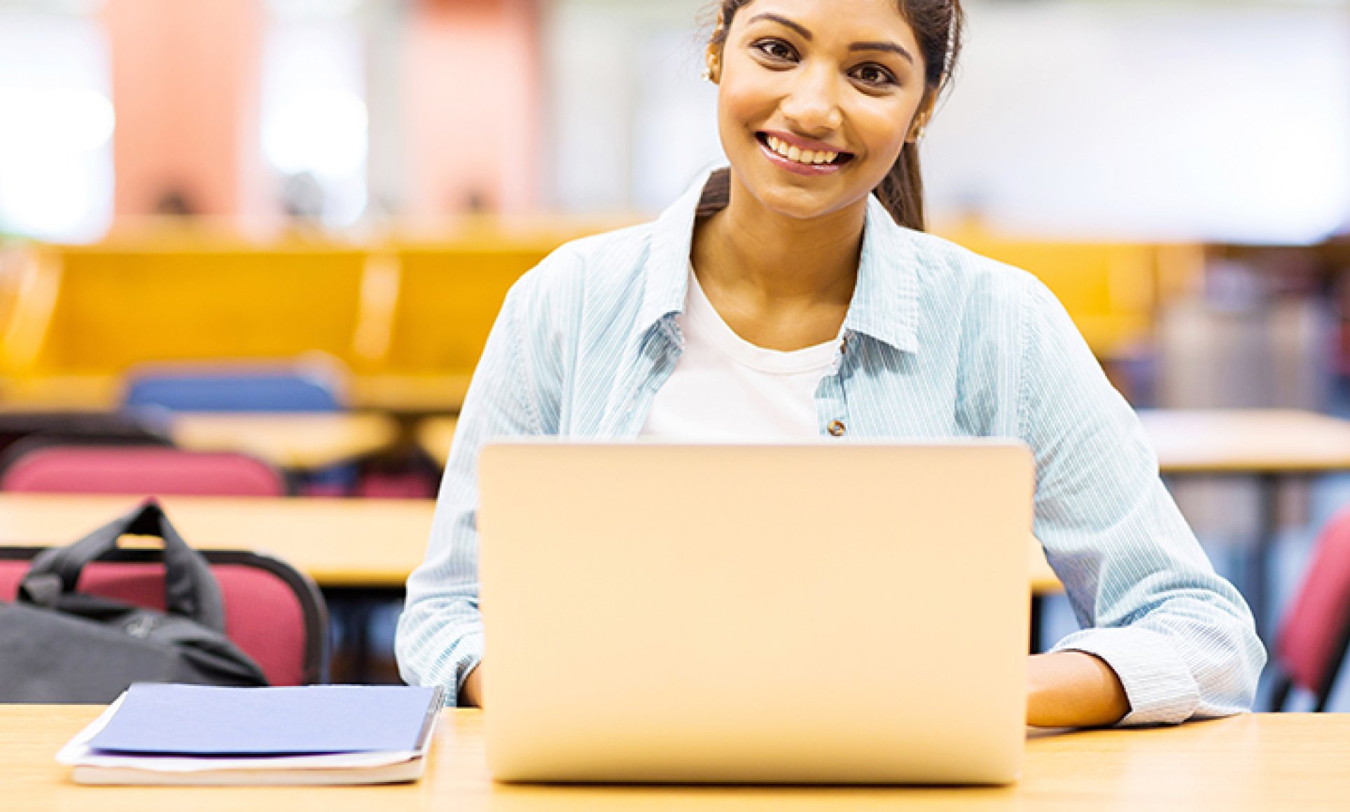 woman in classroom at computer looking at camera