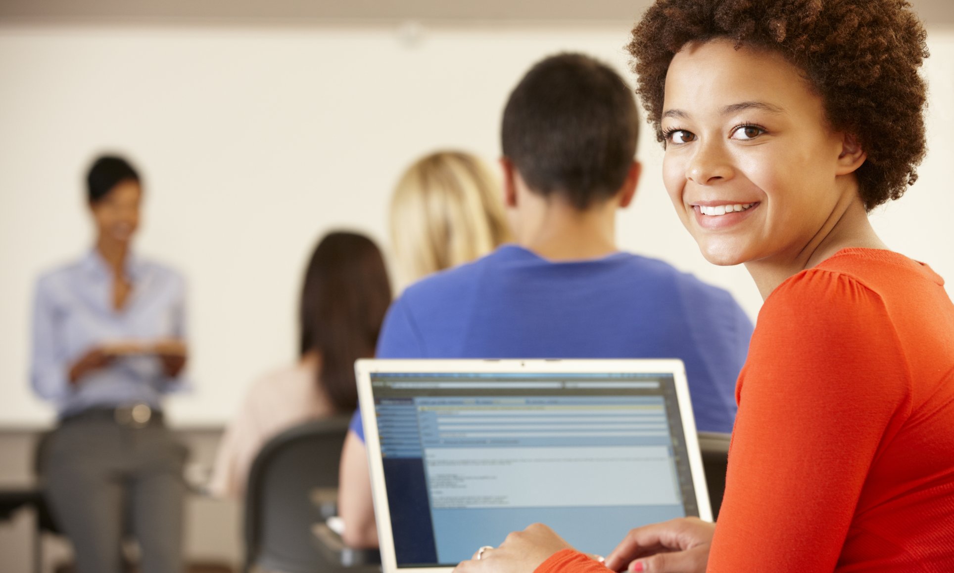 woman on laptop turning and looking at camera