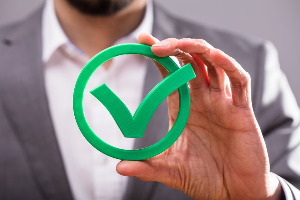 a person holding a circle with a checkmark inside the circle