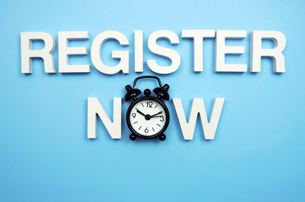 Words "Register Now" with an alarm clock in place of the "O" in "Now"