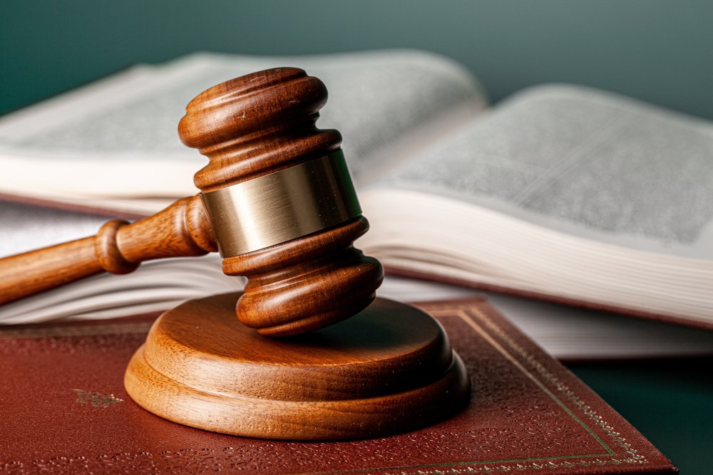 Gavel resting on a table with law books in the background